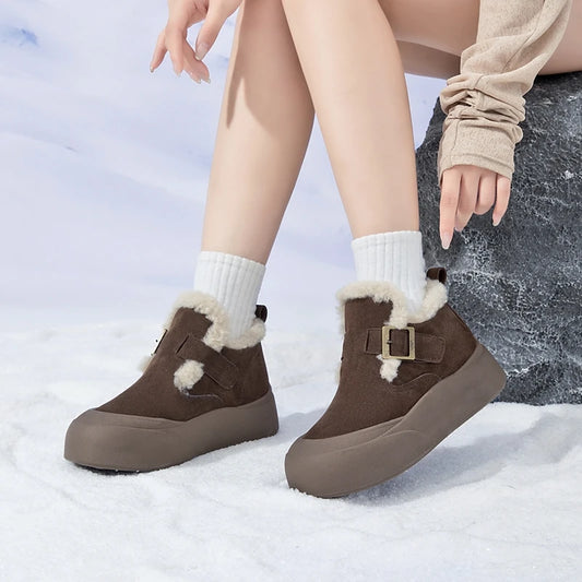 Brown winter boots with fur trim worn by a person on a snowy background