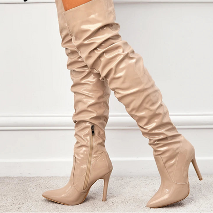 Beige over-the-knee boots with a high heel on a light background