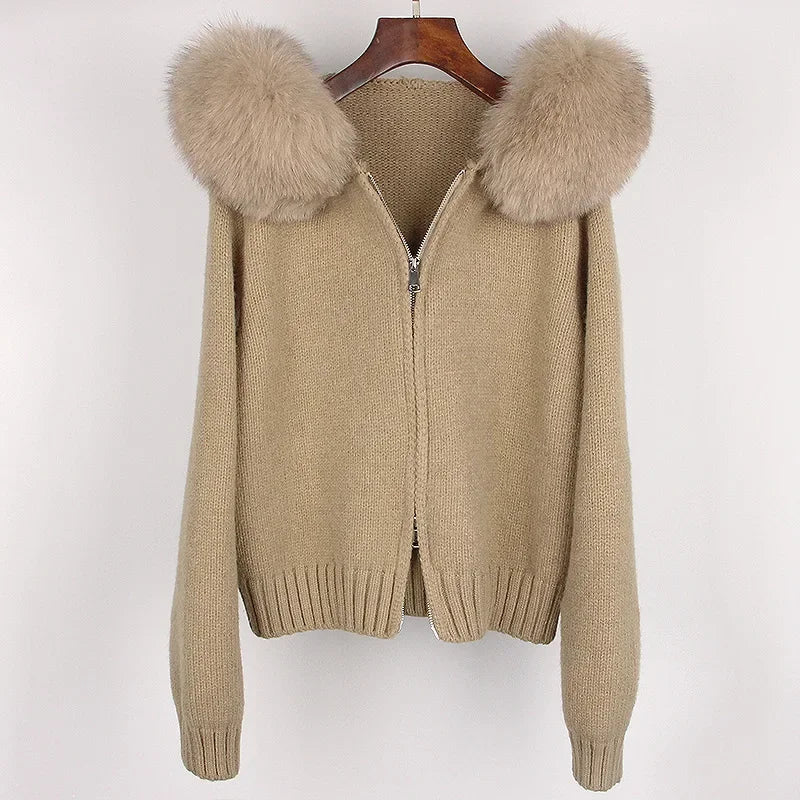 Beige sweater with fur-lined hood on a hanger against a white background