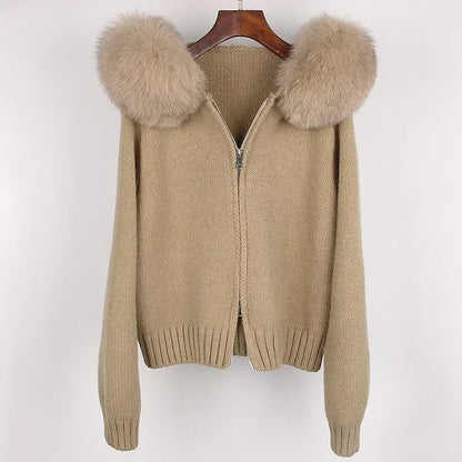 Beige sweater with fur-lined hood on a hanger against a white background