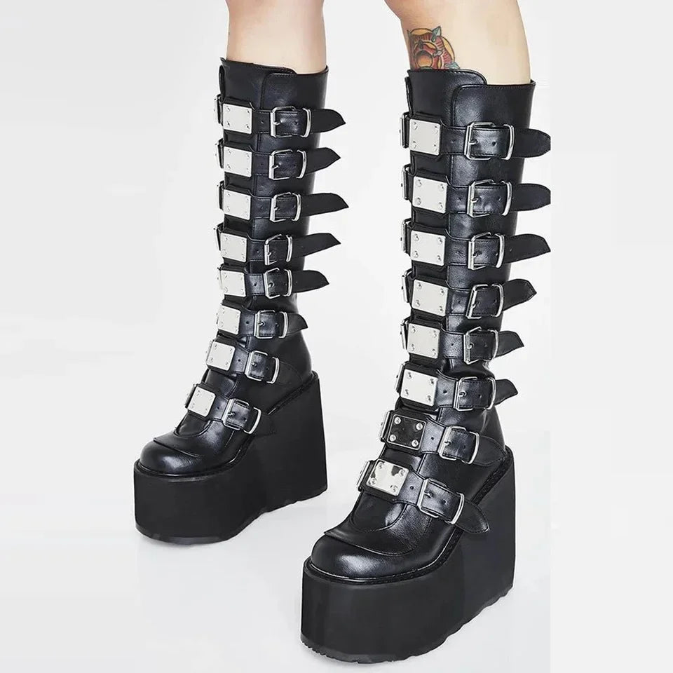 Black platform boots with metal buckles on a white background