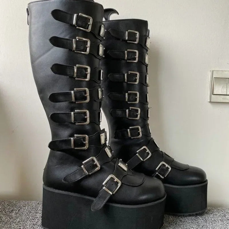 Black platform boots with multiple buckles on a neutral background