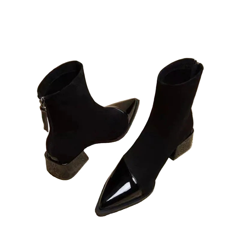 Black pointed-toe ankle boots on a newspaper background