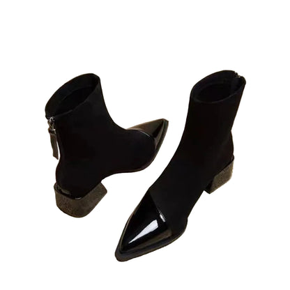 Black pointed-toe ankle boots on a newspaper background