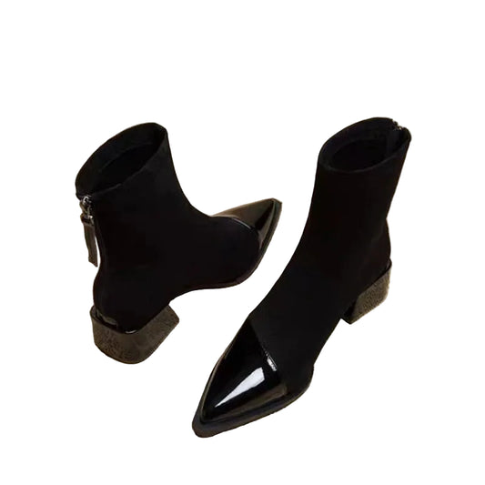 Black pointed-toe ankle boots on a newspaper background