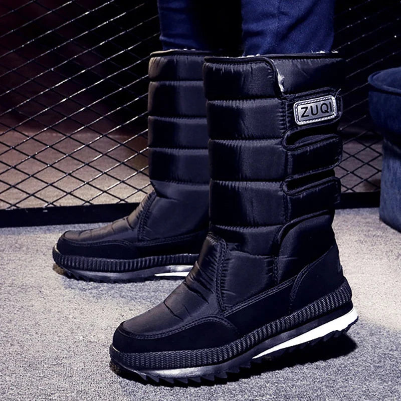 Black winter boots with a visible brand logo on a textured surface.