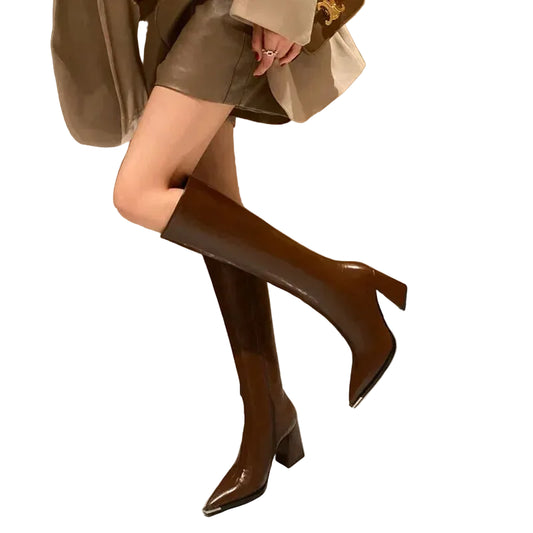 Brown knee-high boots worn by a person sitting on a marble floor.