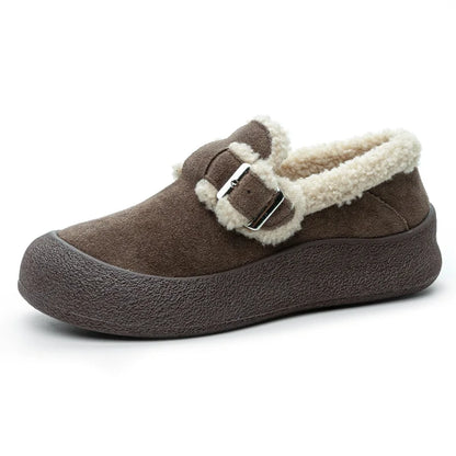Brown slip-on shoe with white fur lining and a buckle on a white background