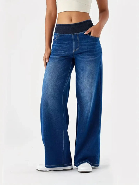 Person wearing blue wide-leg jeans on a white background