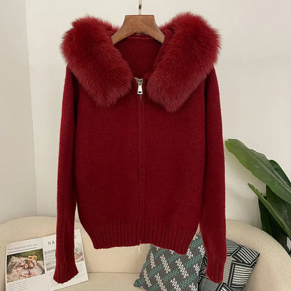 Red sweater with fur collar on a hanger against a neutral background