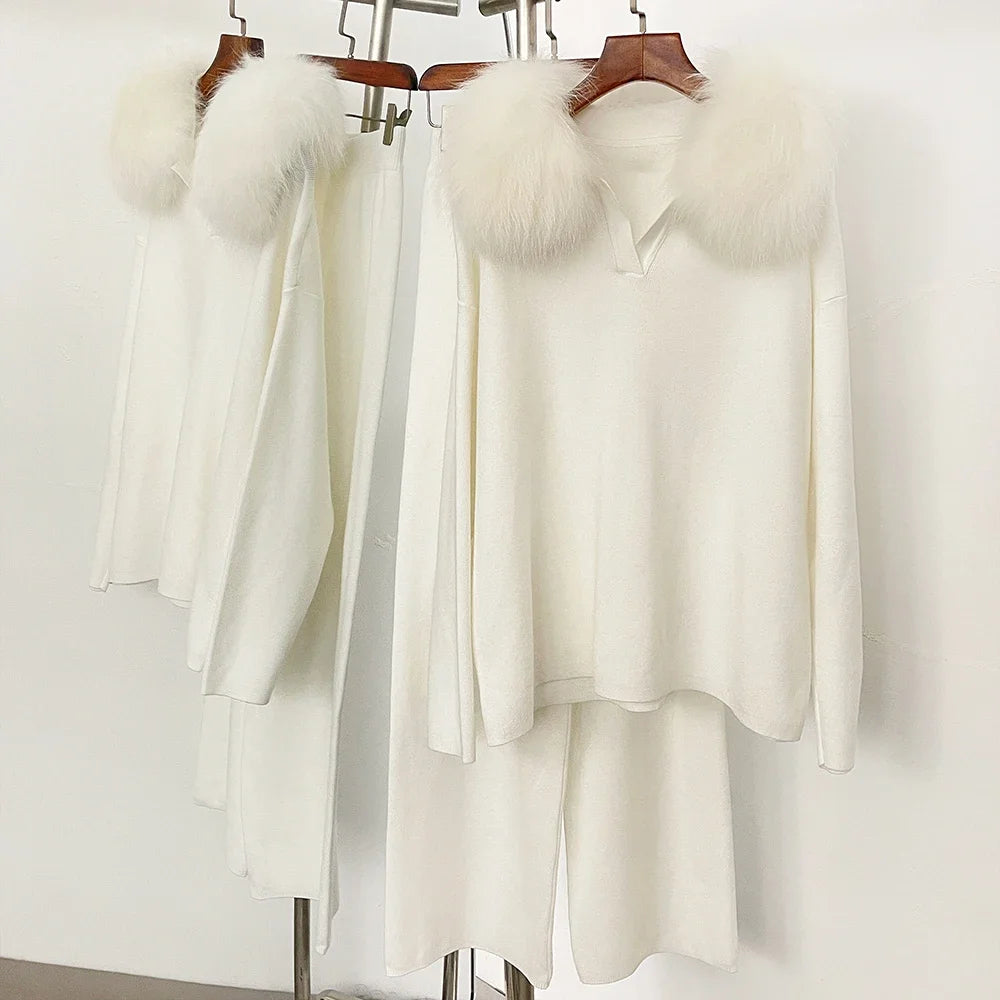 White outfit with fur accents on hangers against a white background