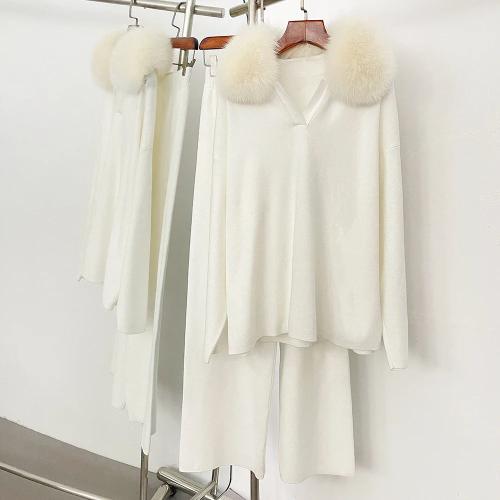 White outfit with fur accents on hangers against a white background