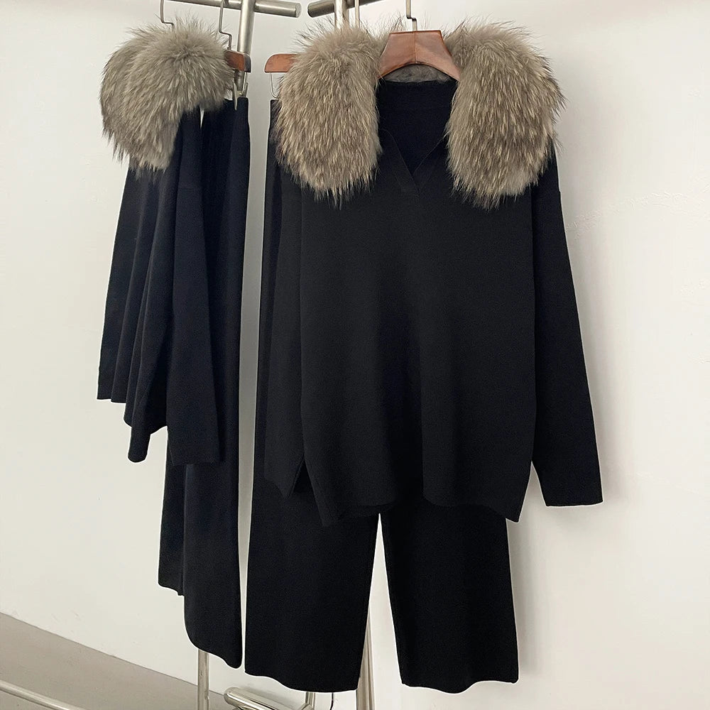 Black coat with fur hood on a rack against a white wall