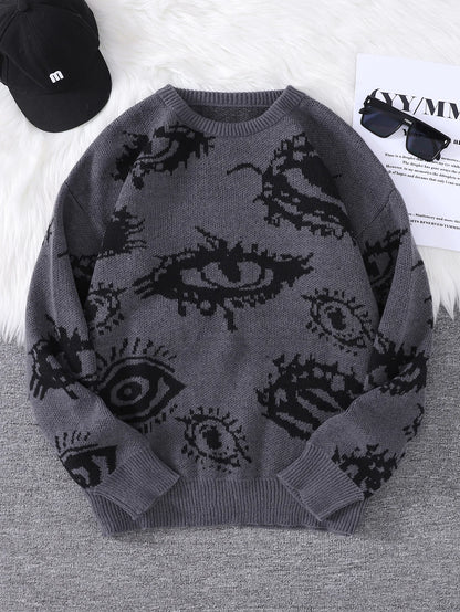 Gray sweater with black eye pattern on a gray surface