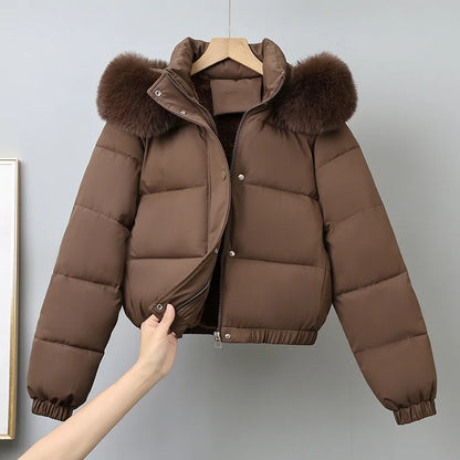 Brown puffer jacket with fur hood on a hanger against a gray background