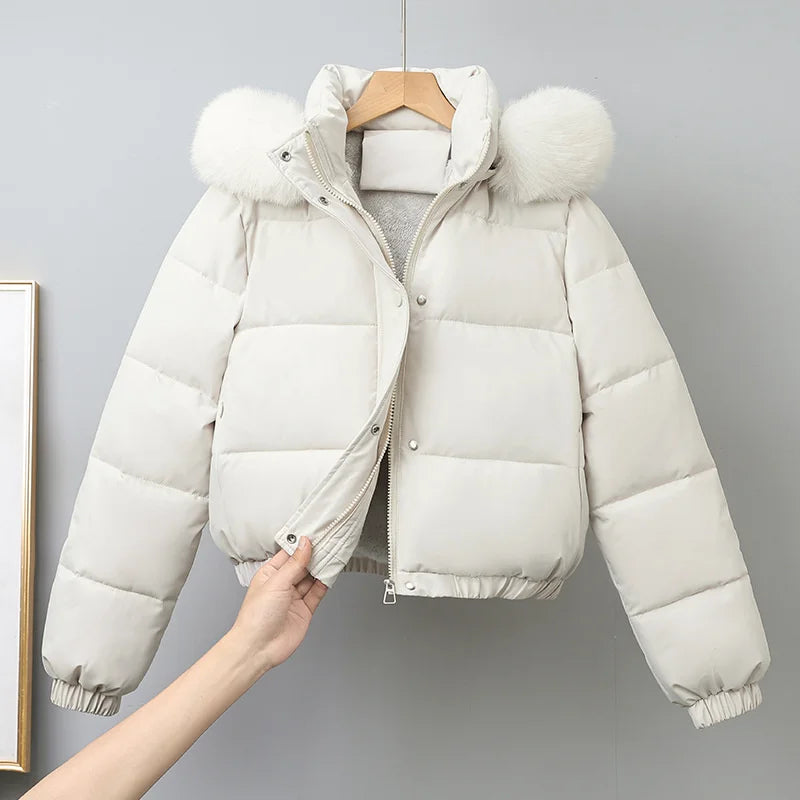 White puffer jacket with fur-lined hood on a gray background