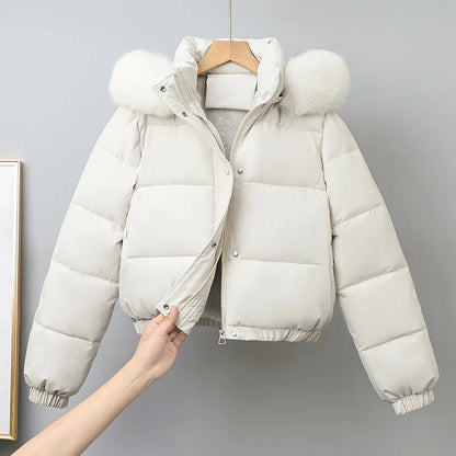 White puffer jacket with fur-lined hood on a gray background