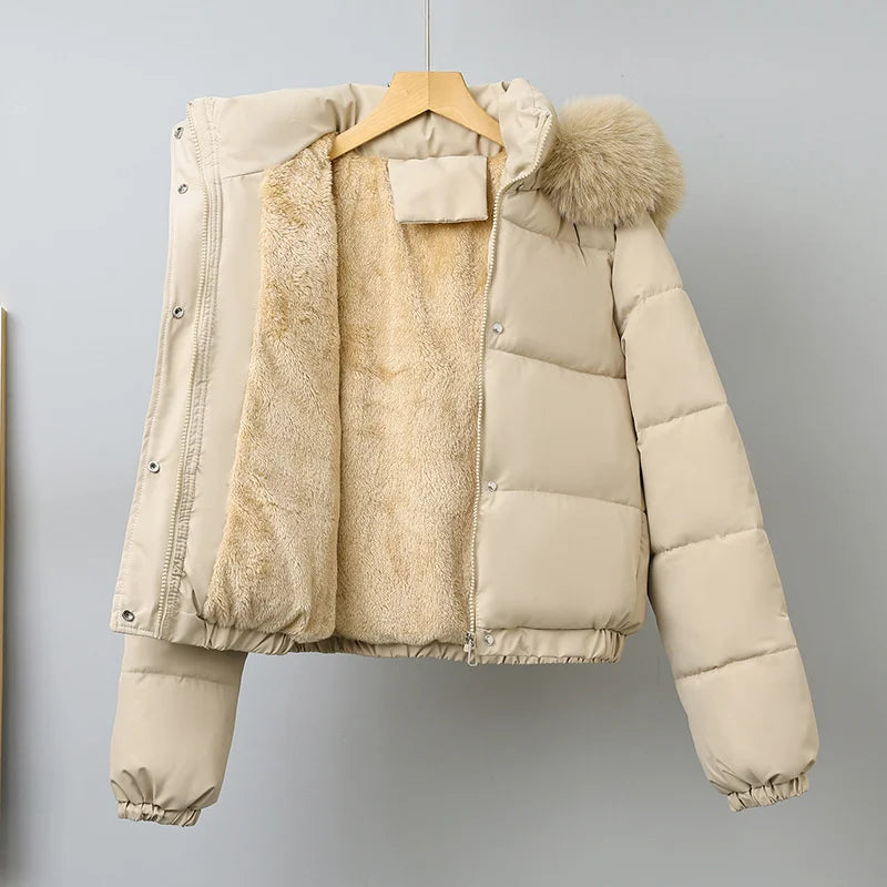 Beige puffer jacket with fur hood on a hanger against a gray background