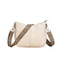 Beige handbag with a decorative strap on a wooden surface