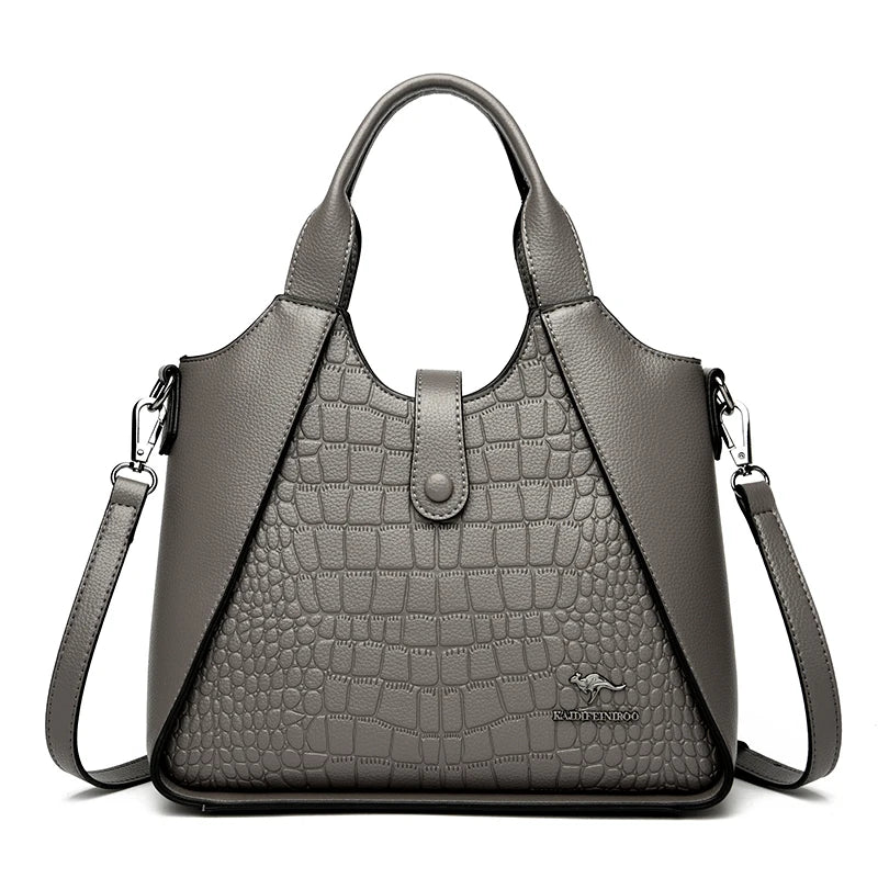 Gray handbag with crocodile texture on a white background