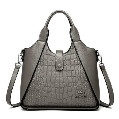 Gray handbag with crocodile texture on a white background