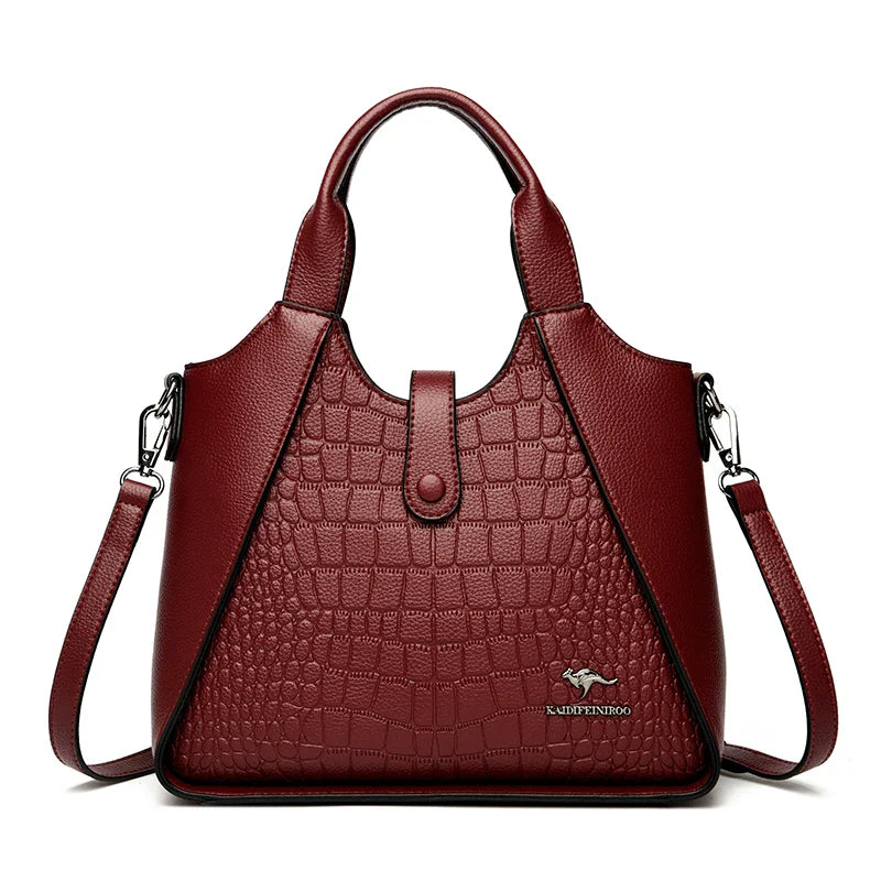 Red handbag with crocodile texture on a white background