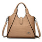 Beige handbag with crocodile texture on a white background