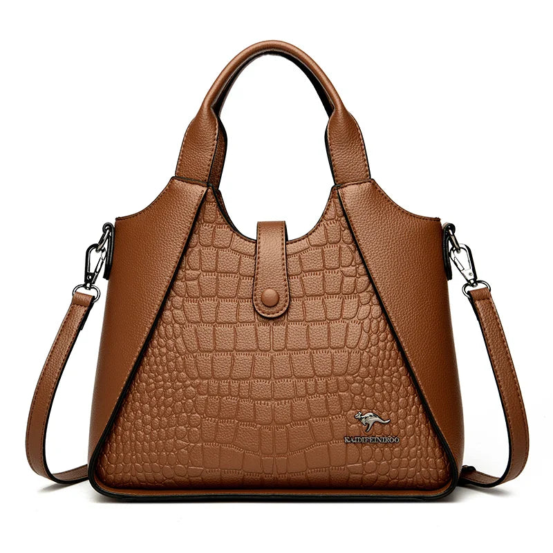 Brown leather handbag with crocodile texture on a white background
