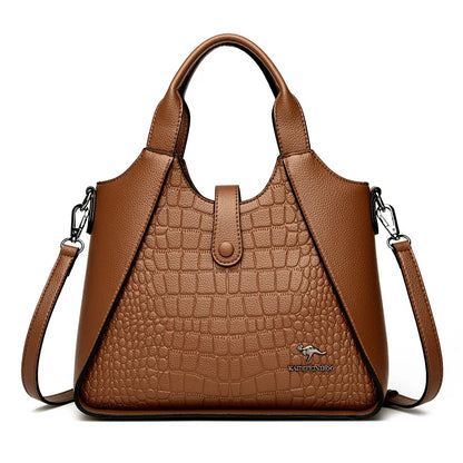 Brown leather handbag with crocodile texture on a white background
