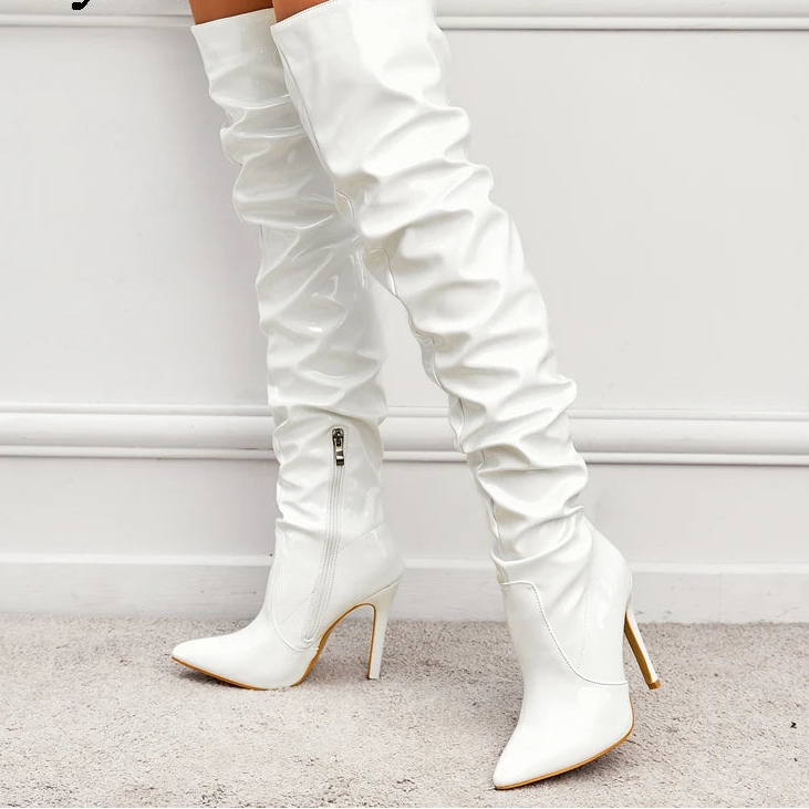 White knee-high boots with high heels on a light background