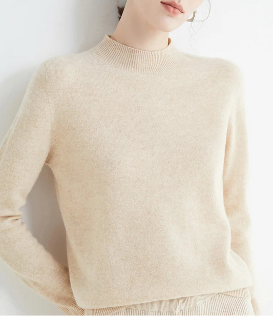 Woman wearing a beige sweater against a white background