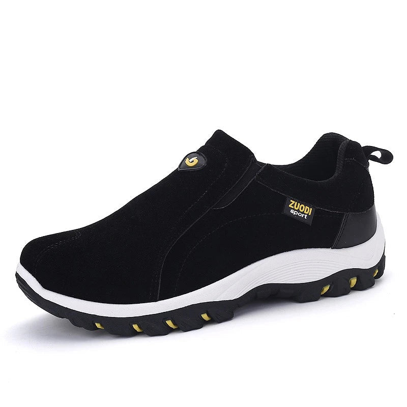 Black slip-on shoes with white sole on a white background