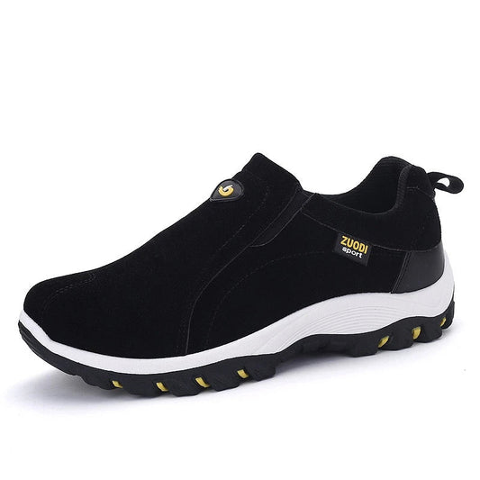 Black slip-on shoes with white sole on a white background