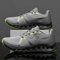 Gray running shoes with green accents on a reflective surface and dark background