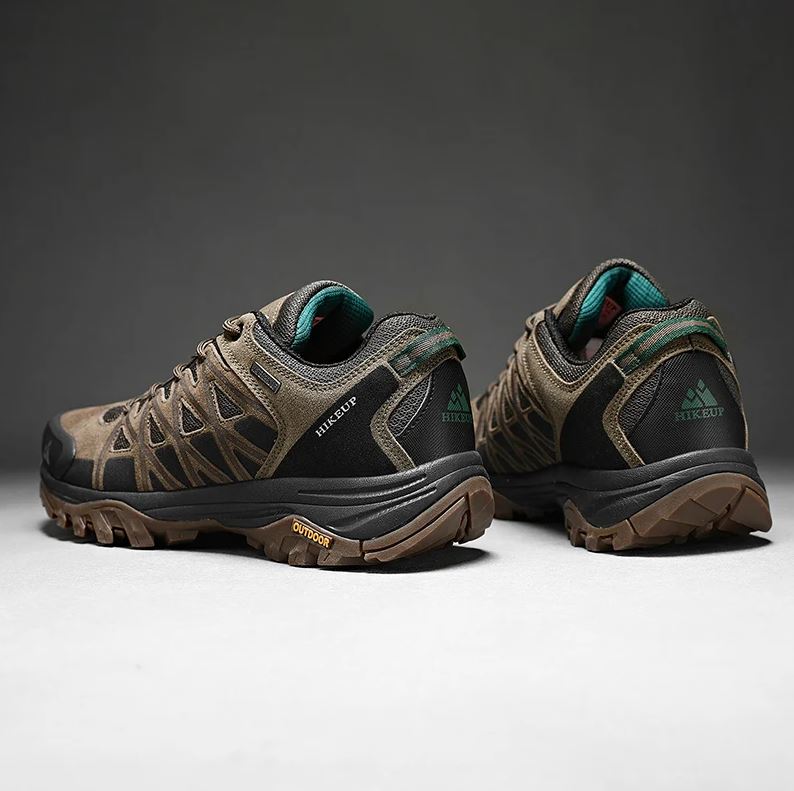 Pair of hiking shoes with visible brand logo on a dark background