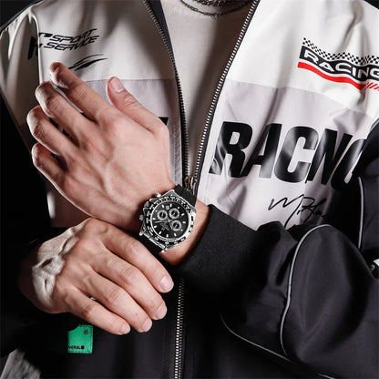 Person wearing a racing-themed jacket with a watch on their wrist.