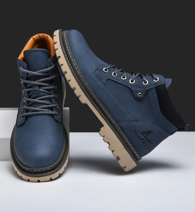 Pair of blue leather boots with brown soles on a white background