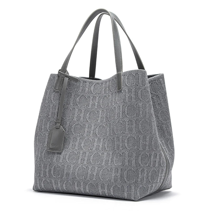 Gray tote bag with a monogram pattern on a white background