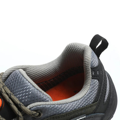 Close-up of a gray and black shoe with orange lining on a white background