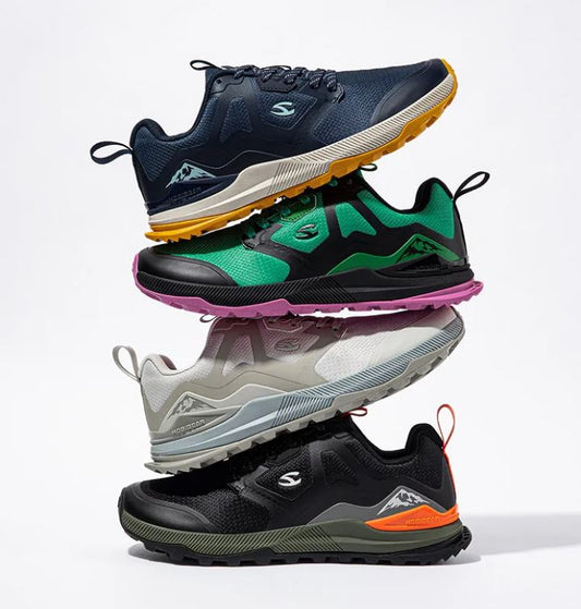 Stack of four different colored athletic shoes on a light gray background