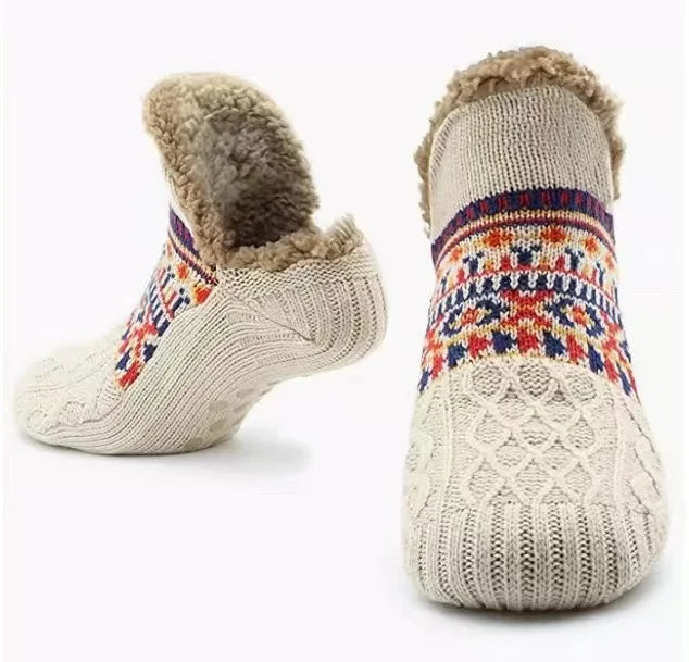 Pair of knitted socks with colorful patterns and fuzzy trim on a white background