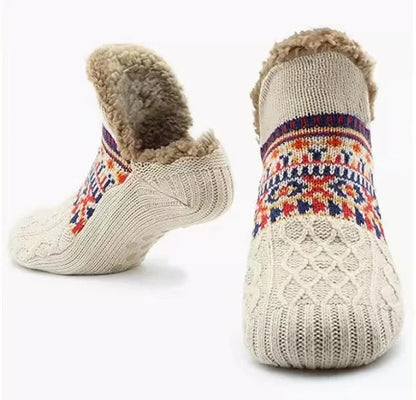 Pair of knitted socks with colorful patterns and fuzzy trim on a white background
