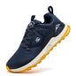 Navy running shoe with yellow sole on a white background