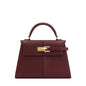 Brown handbag with gold clasp on a white background
