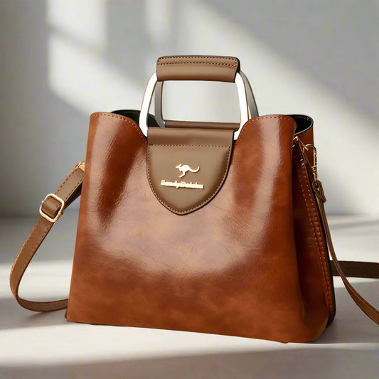 Brown leather handbag with a visible brand logo on a light background
