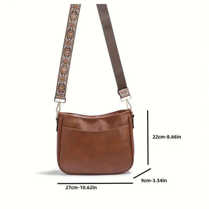 Brown shoulder bag with floral strap and measurements on a white background