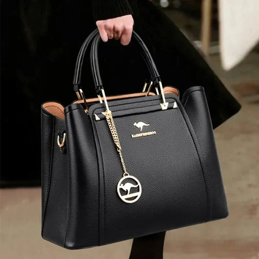 Black handbag with a visible brand logo held by a person.