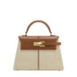 Handbag with brown top section and beige bottom section on a white background